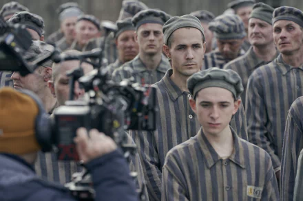 HD desktop wallpaper of a scene from The Tattooist of Auschwitz TV show, depicting actors in prisoner uniforms during filming.