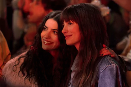 HD desktop wallpaper featuring Anne Hathaway in a scene from the movie The Idea of You, capturing a close and joyful moment with another character at a vibrant event.