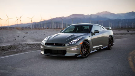 HD desktop wallpaper of a Nissan GT-R parked on a desert road with wind turbines and mountains in the background.