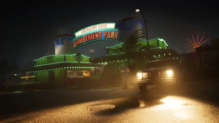 A HD desktop wallpaper featuring an eerie nighttime scene from the video game Killer Klowns from Outer Space: The Game, showing the Crescent Cove Amusement Park lit with neon lights and a car in the foreground.