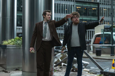 HD desktop wallpaper of a scene from the movie A Quiet Place: Day One, featuring Joseph Quinn and another character standing amidst debris in an urban setting.