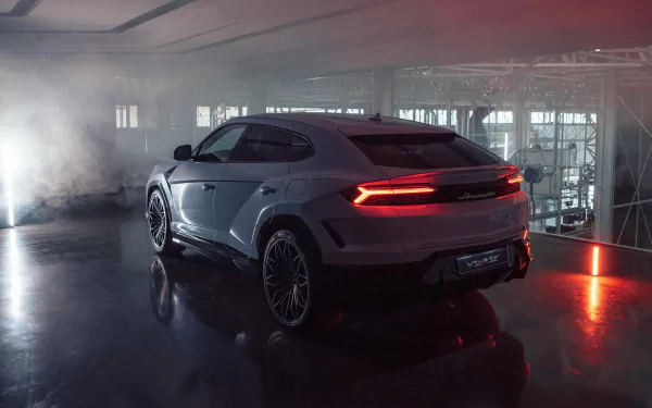 HD desktop wallpaper featuring a Lamborghini Urus parked in a dimly lit garage with atmospheric smoke and glowing red lights.