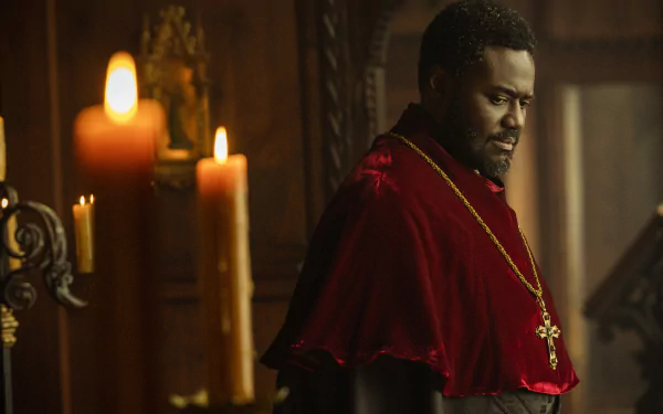 A captivating HD desktop wallpaper from the TV show Shardlake, featuring a character in a red robe with a cross, illuminated by candlelight in a dramatic, historical setting.