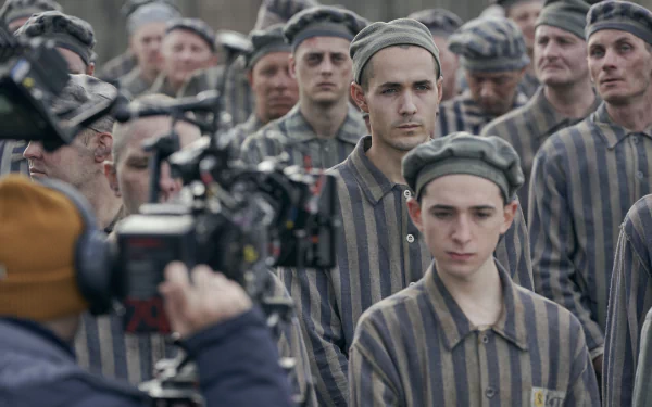 HD desktop wallpaper of a scene from The Tattooist of Auschwitz TV show, depicting actors in prisoner uniforms during filming.