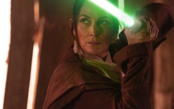 A scene from The Acolyte (2024) TV show featuring a character holding a green lightsaber, captured in an HD desktop wallpaper and background.