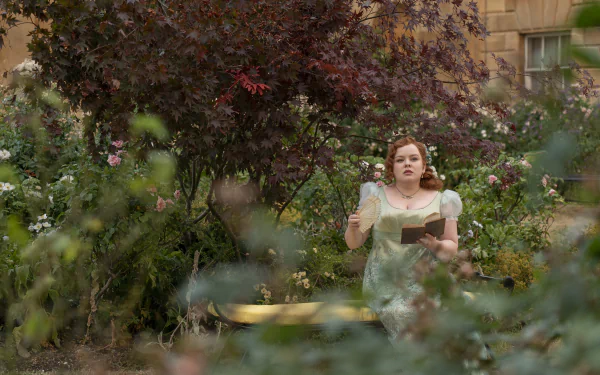 A scene from the TV show Bridgerton features a woman in a light green dress, walking through a lush garden filled with vibrant flowers and greenery, creating a captivating wallpaper backdrop.