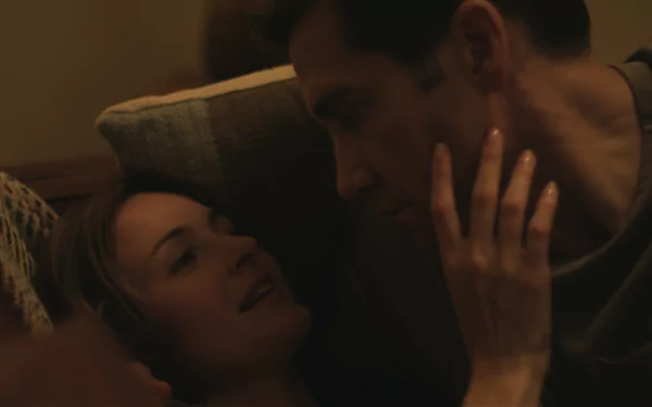 A still from the TV show Presumed Innocent (2024), featuring an intimate moment between two characters, set against a warm-toned background, captured as an HD desktop wallpaper.