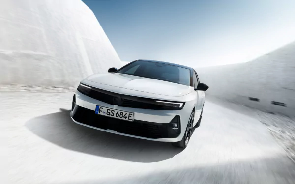 A sleek white Opel Astra GSe drives through a snowy landscape, captured in high definition for a stunning desktop wallpaper and background.