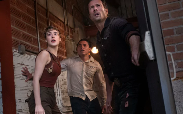 A scene from the movie Twisters featuring Glen Powell and Daisy Edgar-Jones, captured in an intense moment. This HD desktop wallpaper and background sets a dramatic atmosphere.