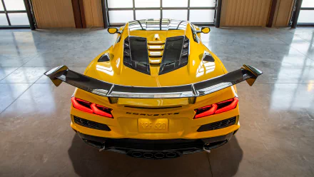 A striking HD wallpaper featuring a yellow Chevrolet Corvette ZR1, showcasing its sleek design and rear spoiler in a modern garage setting.