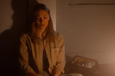 A dramatic scene from the TV show Teacup (2024), featuring Yvonne Strahovski in a dimly lit room, conveying deep emotion and tension. 4K Ultra HD wallpaper for desktop.