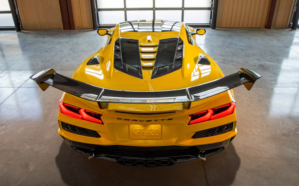 A striking HD wallpaper featuring a yellow Chevrolet Corvette ZR1, showcasing its sleek design and rear spoiler in a modern garage setting.