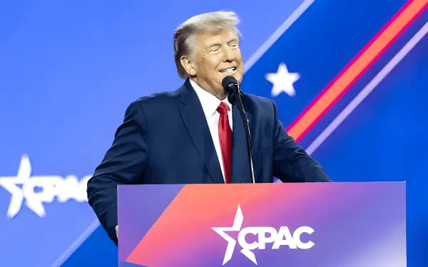 HD desktop wallpaper featuring Donald Trump speaking at a CPAC event with a blue and red MAGA-themed background.