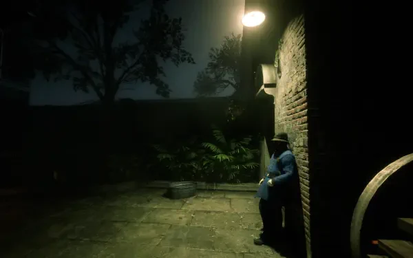 Dark, moody courtyard scene from Red Dead Redemption 2, featuring a lone character seated against a brick wall under a streetlamp, rendered as a HD PC desktop wallpaper.