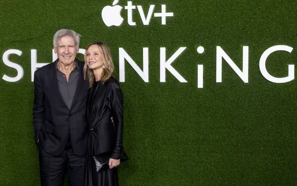 Harrison Ford and Calista Flockhart pose together in front of a green backdrop displaying the title SHRINKING for the Apple TV+ show, captured in a vibrant 4K Ultra HD image.