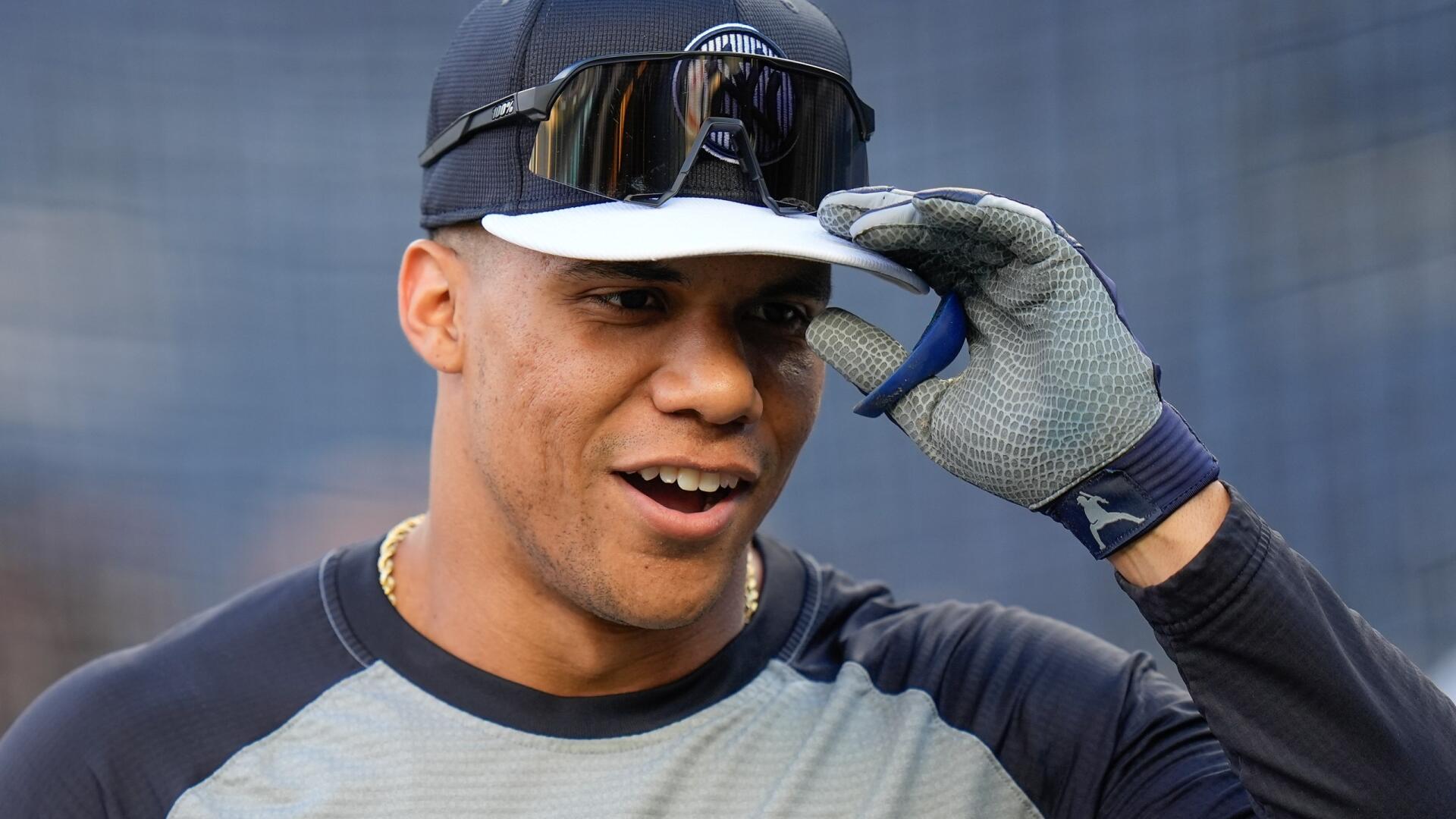 Juan Soto smiles while adjusting his cap on the baseball field. This HD wallpaper captures the excitement of MLB sports and showcases Soto's engaging presence.