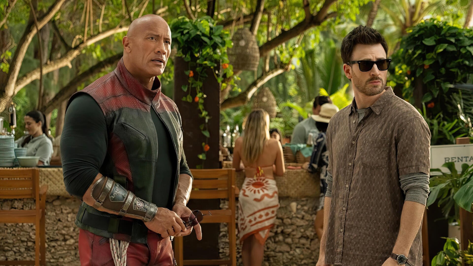 Dwayne Johnson and Chris Evans star in Red One, captured in this vibrant 4K Ultra HD wallpaper, set against a lush tropical backdrop.
