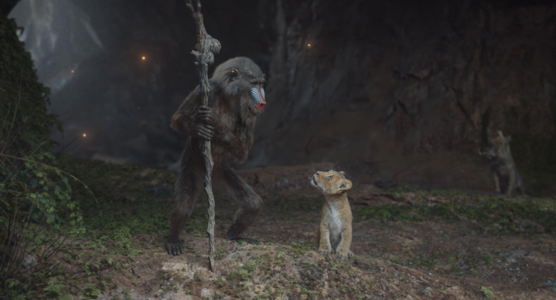 A vibrant HD wallpaper from Mufasa: The Lion King, featuring a wise baboon holding a staff, standing beside a young lion in a mystical, shadowy landscape.