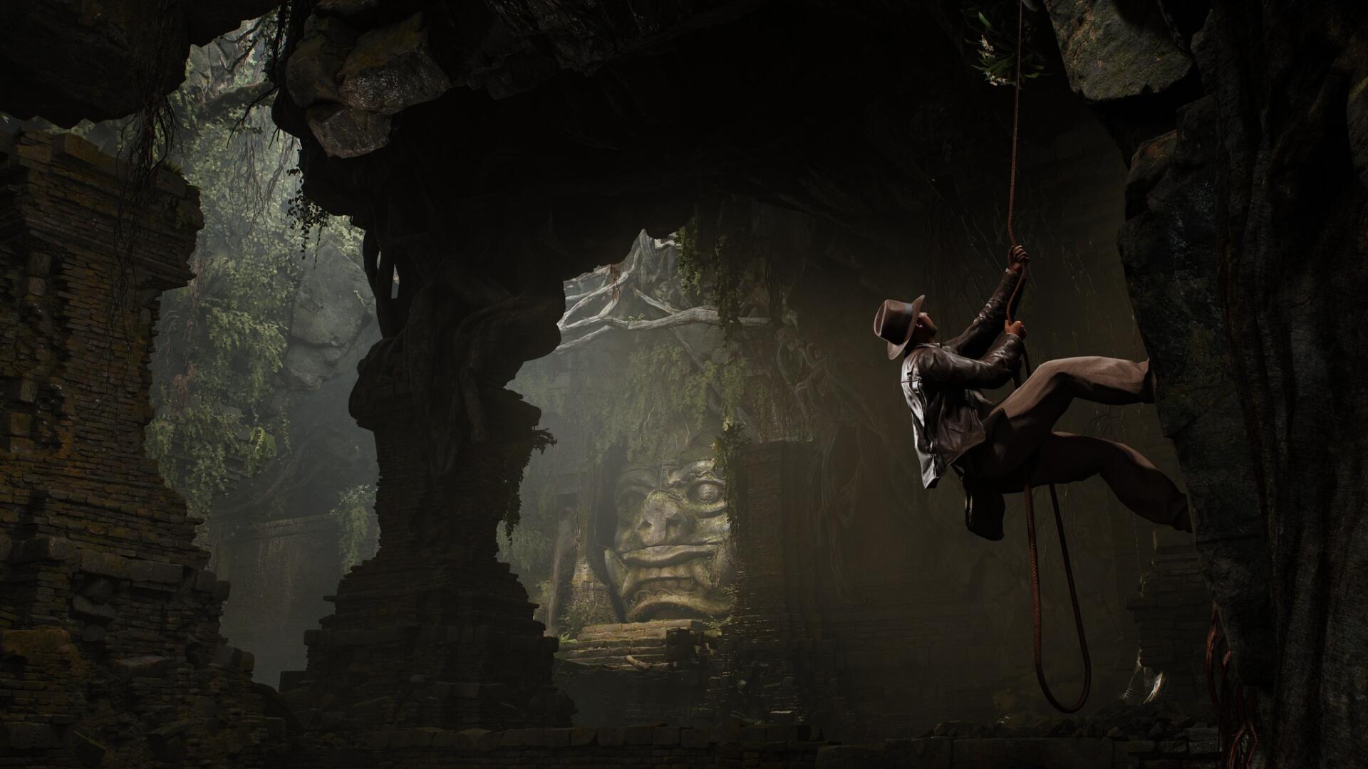 An adventurous scene from Indiana Jones and the Great Circle, featuring Indiana Jones descending into a shadowy cave, surrounded by ancient ruins and dramatic lighting. HD PC wallpaper.