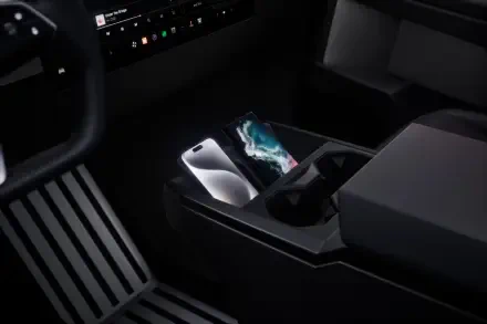 A close-up view of the Tesla Cybertruck's interior, showcasing the sleek design with a focus on the modern center console and a smartphone in the cup holder. 4K Ultra HD wallpaper.
