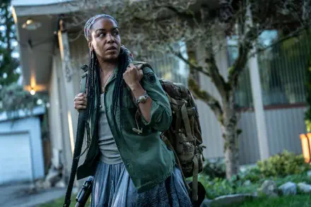 An HD desktop wallpaper featuring Jessica Frances Dukes in Earth Abides, confidently carrying a backpack and looking determined amidst a natural backdrop.