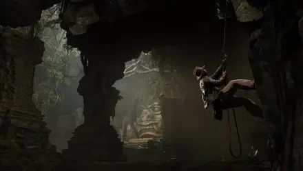 An adventurous scene from Indiana Jones and the Great Circle, featuring Indiana Jones descending into a shadowy cave, surrounded by ancient ruins and dramatic lighting. HD PC wallpaper.