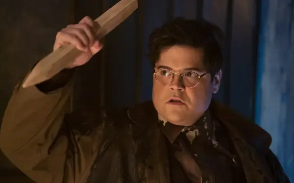 Harvey Guillén in a dramatic scene from the TV show What We Do in the Shadows, holding a wooden object, captured in a high-definition desktop wallpaper.