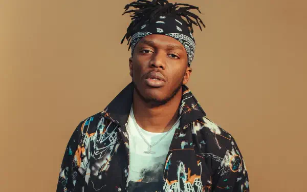 High-definition desktop wallpaper featuring KSI, showcasing him in a stylish outfit with a bandana against a warm beige background.