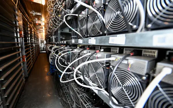 A detailed view of a crypto mining setup, showcasing rows of powerful cooling fans and intricate wiring in a high-tech environment, presented as a 4K Ultra HD desktop wallpaper.