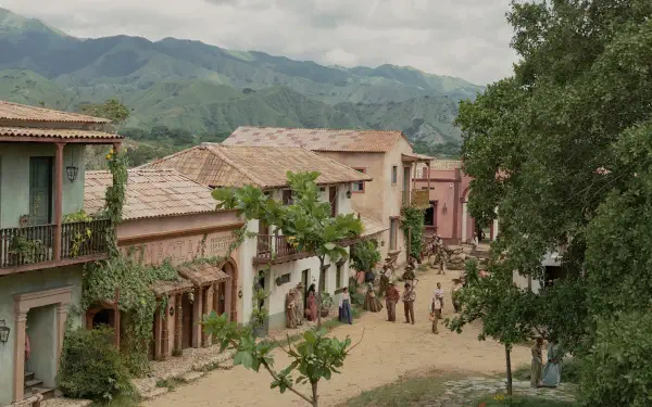 HD PC desktop wallpaper depicting a scenic village scene from the TV show One Hundred Years of Solitude, featuring rustic buildings and lush green mountains.