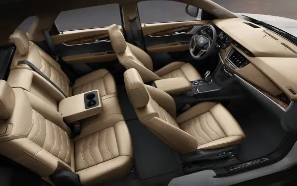 Interior view of a Cadillac XT5, showcasing luxurious beige seating and a modern dashboard, designed for comfort and style. High-definition image suitable as a desktop wallpaper.
