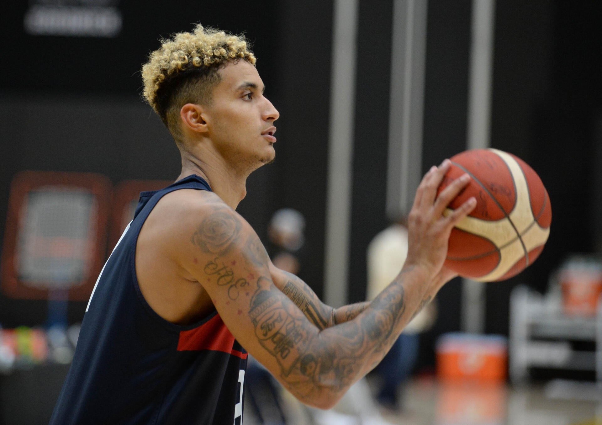 A dynamic HD wallpaper featuring Kyle Kuzma, a basketball player, capturing a moment as he prepares to make a shot during practice, showcasing his athleticism and focus.
