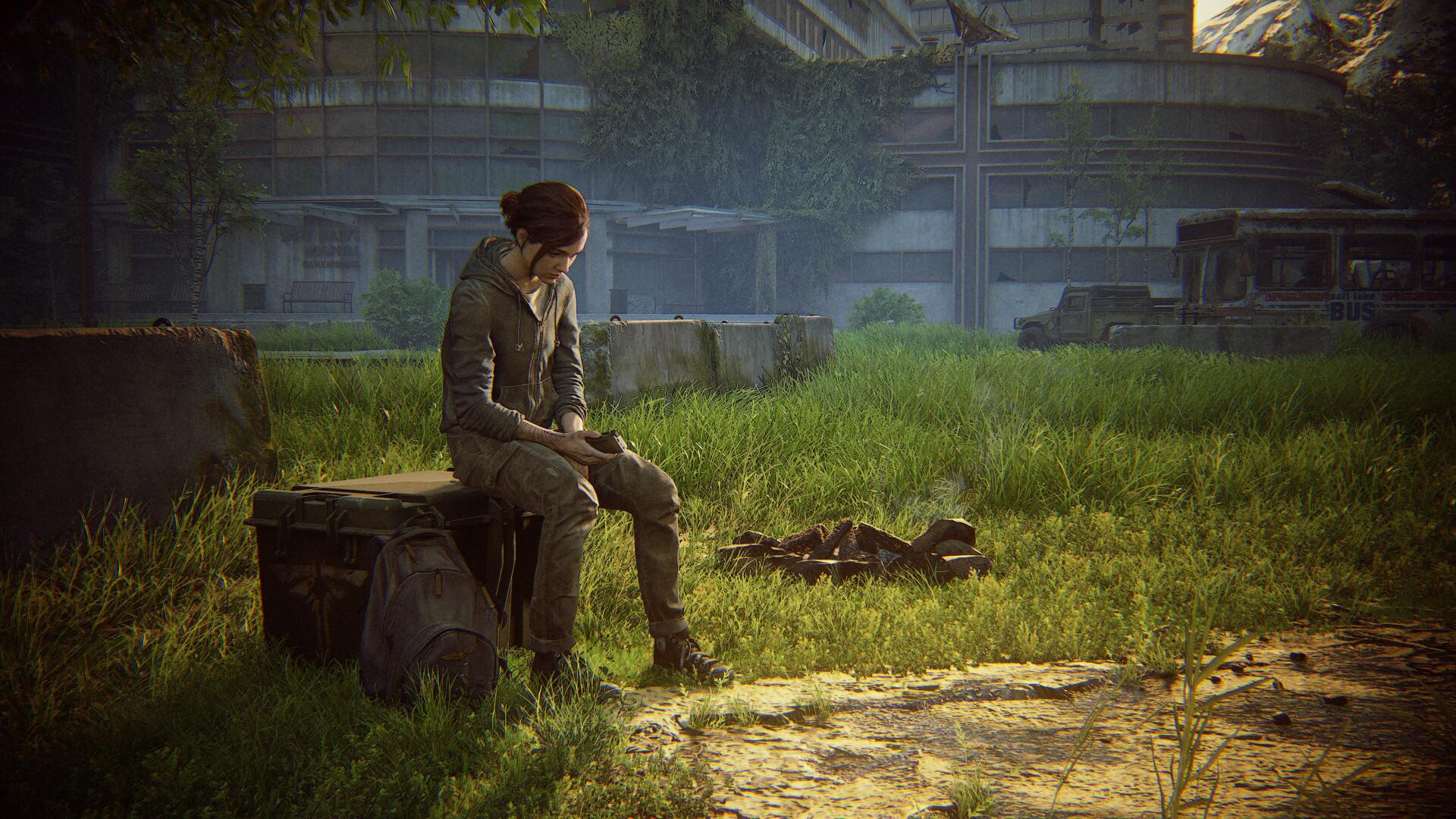 Ellie from The Last of Us Part II sits on a crate in an overgrown urban landscape, depicted in a 4K Ultra HD PC desktop wallpaper from the video game.