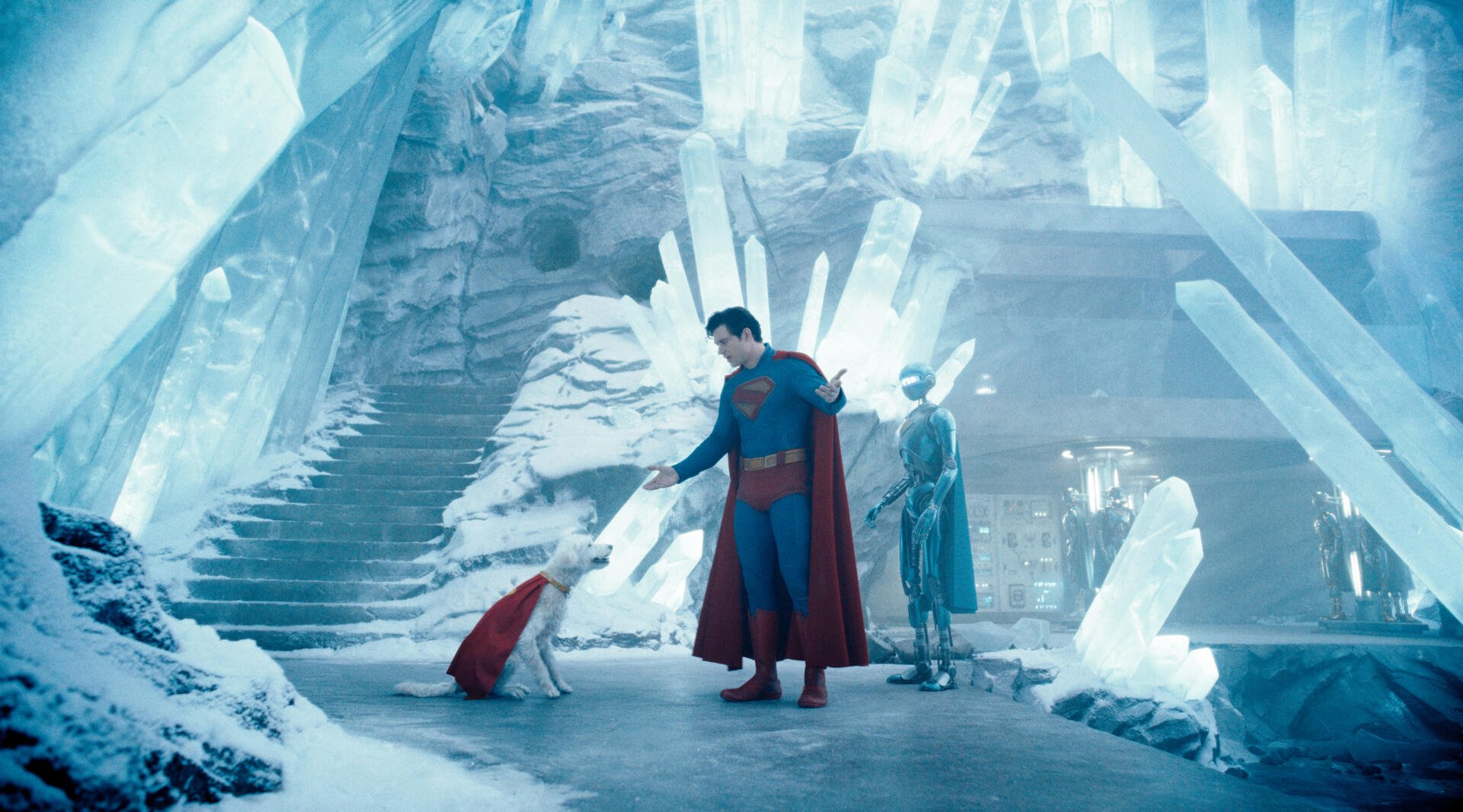Superman (2025) stands in an icy cavern with crystalline structures, accompanied by two figures, captured in stunning 4K Ultra HD for a PC desktop wallpaper.