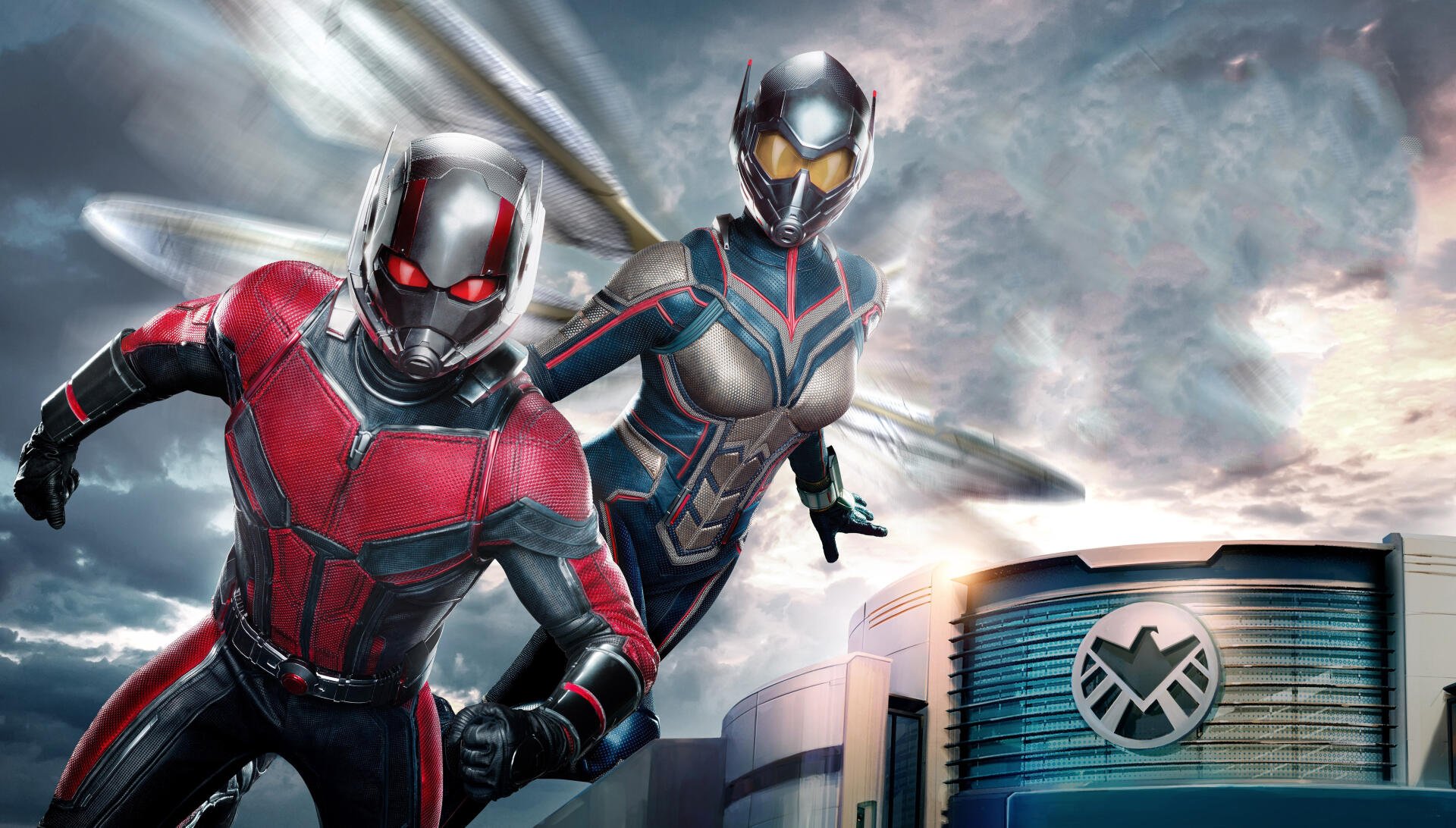 Ant-Man and the Wasp soar above S.H.I.E.L.D. HQ in a dynamic 4K Ultra HD PC desktop wallpaper/background with dramatic clouds, motion blur, and heroic action pose.