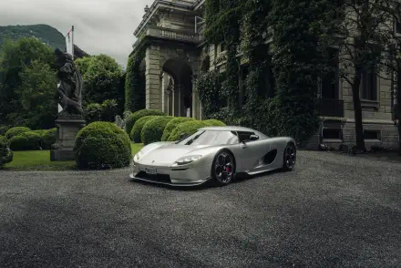 A stunning Koenigsegg CC850 parked in an elegant outdoor setting, showcasing its sleek design against a backdrop of lush greenery and classical architecture. 8K Ultra HD quality.