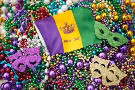 A vibrant celebration of Mardi Gras, featuring a flag, colorful beads, and festive masks, creates a lively backdrop for this HD desktop wallpaper and background.
