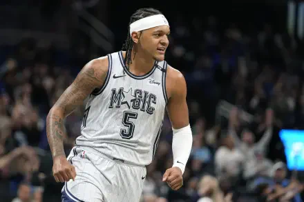 HD desktop wallpaper featuring Orlando Magic player Paolo Banchero celebrating during an NBA game, capturing the energy and excitement of basketball.