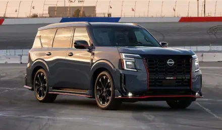 A sleek Nissan Armada NISMO SUV in dark gray with red accents, showcased on a race track, captured in high definition as a PC desktop wallpaper and background.