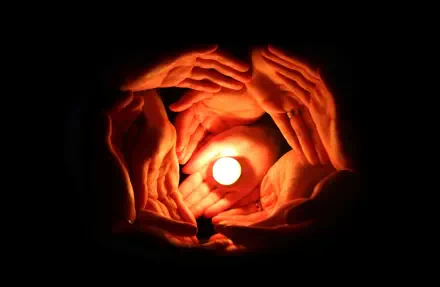 Multiple hands circle a glowing candle, symbolizing family, love and togetherness — HD PC desktop wallpaper/background.