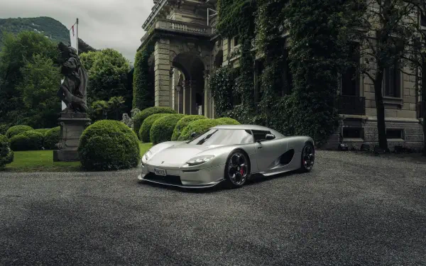 A stunning Koenigsegg CC850 parked in an elegant outdoor setting, showcasing its sleek design against a backdrop of lush greenery and classical architecture. 8K Ultra HD quality.