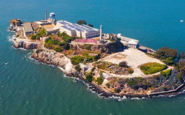 Aerial view of Alcatraz Island in California surrounded by blue waters, captured in high definition for a vibrant PC desktop wallpaper.