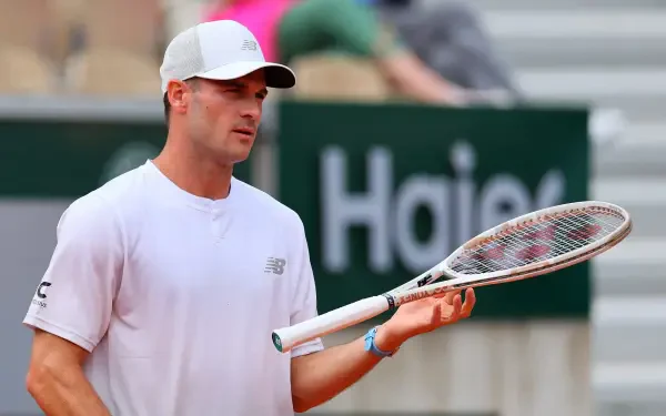 HD desktop wallpaper featuring tennis player Tommy Paul holding a racket on the court during a match.