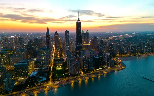 A stunning 4K Ultra HD cityscape of Chicago, Illinois, showcasing illuminated skyscrapers along the lakeshore at sunset in the USA.