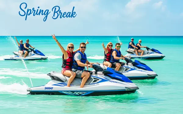 Five people enjoying jet skiing on clear turquoise water under a sunny blue sky, captured in a vibrant 4K Ultra HD spring break PC desktop wallpaper.