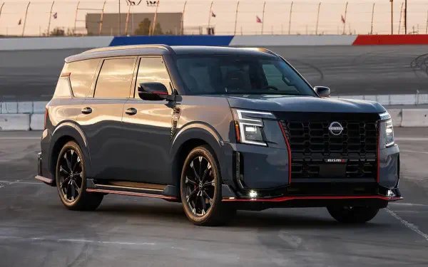A sleek Nissan Armada NISMO SUV in dark gray with red accents, showcased on a race track, captured in high definition as a PC desktop wallpaper and background.