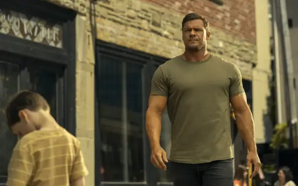 HD desktop wallpaper featuring Alan Ritchson as Reacher from the TV show, walking confidently down a city street.