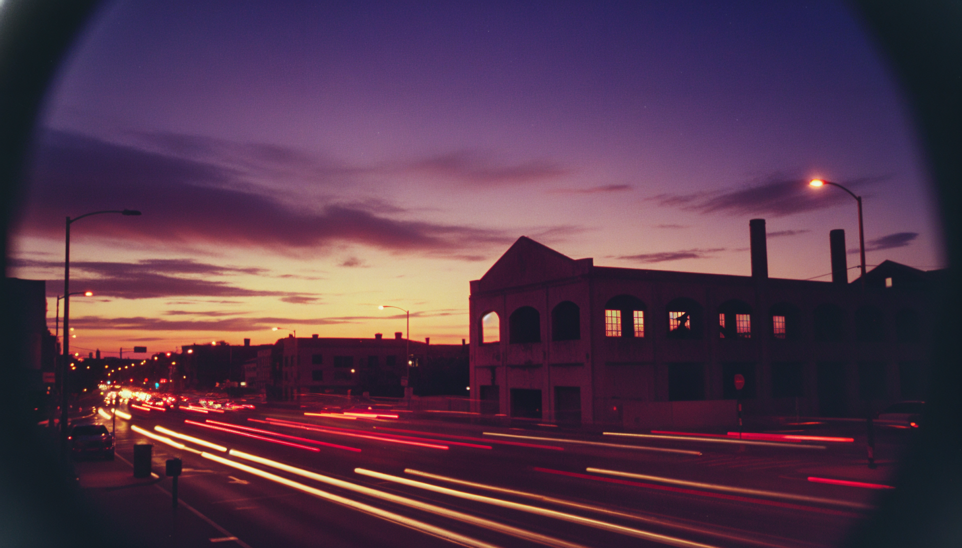 HD PC desktop wallpaper and background: long-exposure dusk cityscape with streaking car lights, silhouetted buildings and a purple-orange sky.