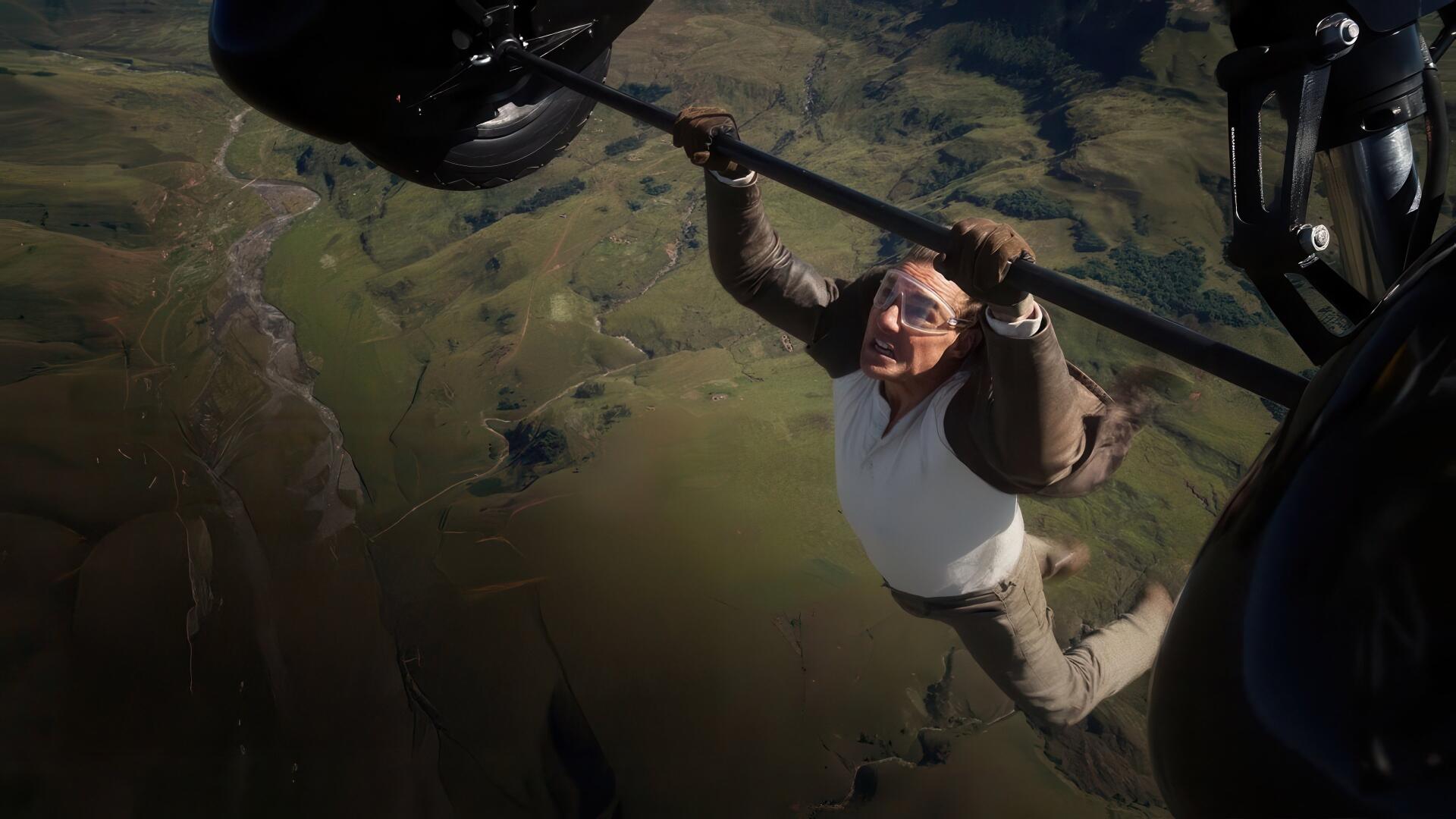 Mission: Impossible - The Final Reckoning 4K Ultra HD PC desktop wallpaper: a man clinging to a helicopter strut over rolling green countryside.