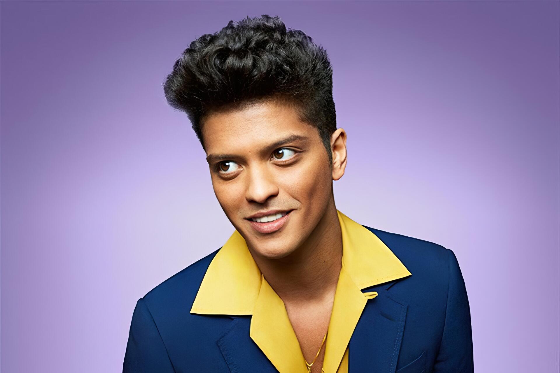 Music-themed HD desktop wallpaper: vibrant portrait of a smiling male pop singer in a blue suit with a yellow open-collar shirt against a soft purple gradient background.